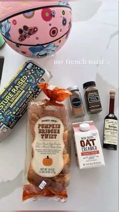 an assortment of food and condiments sitting on a white counter top next to a pink purse