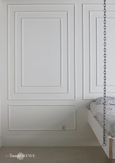 a bedroom with white paneling and a bed