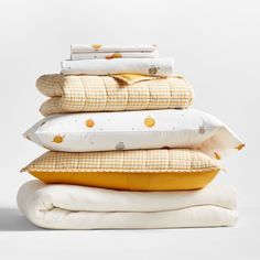 four pillows stacked on top of each other in front of a white background with gold polka dots