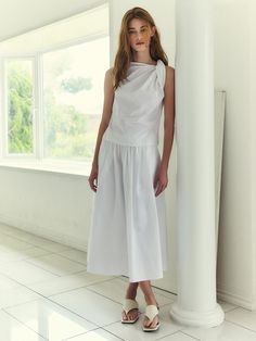 This elegant maxi skirt features a voluminous A-line silhouette, creating a graceful and flowing appearance. The skirt is designed with a high waist and ample gathers, which enhance its fullness and movement. It is made from a soft, lightweight fabric that drapes beautifully, making it perfect for both casual and formal occasions. The elastic waistband ensures a comfortable and adjustable fit, accommodating a range of body sizes.- The high waist and gathered design of the skirt accentuate the waistline and provide a flattering shape.- Its classic black color adds versatility, allowing it to be paired easily with various styles of tops and accessories.- The maxi length and fluid drape of the skirt offer a timeless elegance, suitable for a variety of settings from day-to-night wear. Chic A-line Maxi Skirt For Daywear, Spring Maxi Dress With Voluminous Flared Skirt, Chic Spring Draped And Gathered Skirt, White Flowy Draped Skirt For Evening, Spring Maxi Dress With Flared Gathered Skirt, Spring Maxi Dress With Gathered Flared Skirt, Chic Dress With Relaxed Gathered Skirt, Chic Relaxed Dress With Gathered Skirt, Chic Flowy Maxi Skirt With Folds