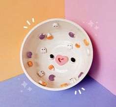 a white bowl with faces painted on the side and holes in the middle to make them look like pigs