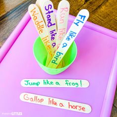 toothbrushes with writing on them sitting in a green cup filled with pencils that read jump like a frog gallop like a horse