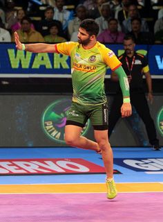 a man in green and yellow uniform playing with a tennis racquet on a court