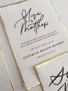 the wedding stationery is laid out on top of each other, with gold foil