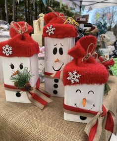 three snowmen made out of wooden blocks on a table