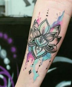 a woman's arm with a watercolor lotus tattoo on the left side of her body