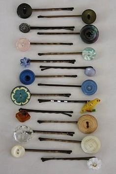 several different types of sewing needles are arranged on a white surface with buttons and thread spools