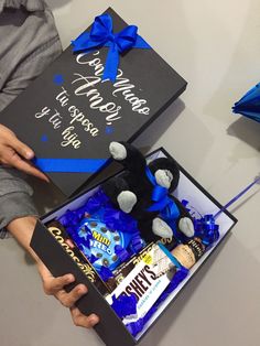 someone is holding a graduation cap and some candy in a gift box with congratulations written on it