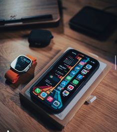 an apple watch sitting on top of a wooden table next to a cell phone and charger