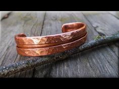 two copper bracelets sitting on top of a wooden table