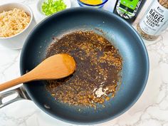 a frying pan filled with food on top of a counter next to other ingredients