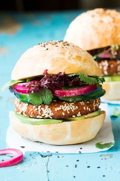 two burgers with lettuce, radishes and onions on buns