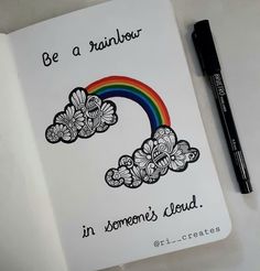 a notebook with an image of a rainbow on it and a pen next to it