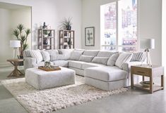 a living room with a large sectional couch and ottoman in the corner, along with a coffee table