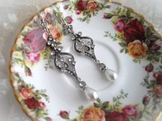 two pairs of scissors on a plate with flowers and lace in the tablecloths