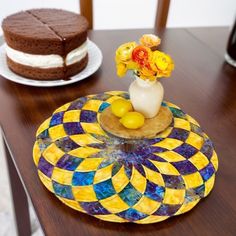 there is a cake and vase with flowers on the table