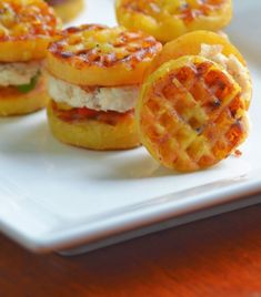 small sandwiches with cheese and tomato slices on a white plate