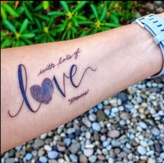 a person's arm with a tattoo that says love and a fingerprint in the shape of a heart