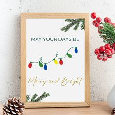 a christmas card with pine cones and lights on it next to a potted plant