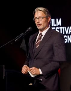 a man standing at a podium in front of a microphone