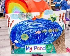 a young child holding up a painting made to look like a fish