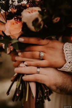 the bride and groom are holding hands with their wedding rings on top of each other