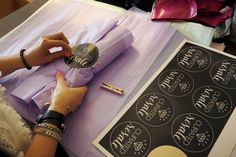 a woman is cutting out some paper with scissors and writing on the front of it