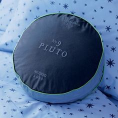 a round pillow sitting on top of a bed covered in blue and white sheets with stars