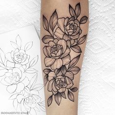 a black and white flower tattoo on the right arm, next to a drawing of flowers