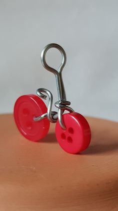 two red buttons attached to a metal hook