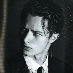 black and white photograph of a young man with wet hair wearing a suit, shirt and tie