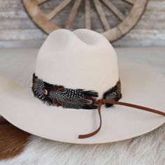 The Falcon Western Feather Hat Band boasts a width of 4 cm and an approximate length of 58 cm, excluding the leather ties. Designed to fit most sizes, this adjustable hat band features leather ties for a secure and comfortable fit. Please note that this product includes one single hat band and does not come with a hat. The feather detailing adds a bold touch of western flair, making it a distinctive addition to any hat. Adjustable Hat Bands For Country Events In Fall, Adjustable Country Hat Bands For Fall, Adjustable Flat Brim Country Fedora, Adjustable Wide Brim Top Hat For Country Events, Adjustable Wide Brim Country Style Top Hat, Country Style Fedora With Adjustable Curved Brim, Country Style Adjustable Fedora With Flat Brim, Country Style Adjustable Fedora With Curved Brim, Country Style Adjustable Wide Brim Top Hat