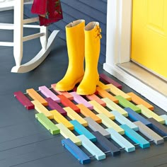 a child's yellow rain boot standing on top of a colorful wooden block mat