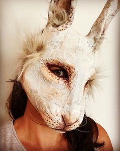 a woman wearing a white rabbit mask with long hair