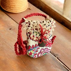 a small handbag sitting on top of a wooden table next to a straw hat