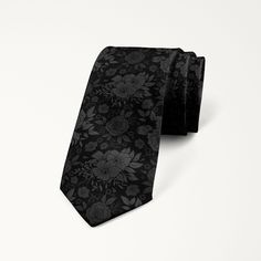 This stylish wedding tie features a floral pattern in the black and gray monochromatic color scheme that should coordinate well with any color suits and dresses. Black Standard Tie For Wedding Suits, Black Tie Accessories For Groom, Elegant Black Ties For Groom, Black Floral Tie, Classic Patterned Ties For Black Tie Events, Grey Suit Floral Tie, Classic Black Ties For Groom, Black Ties With Design, Floral Print Ties For The Groom