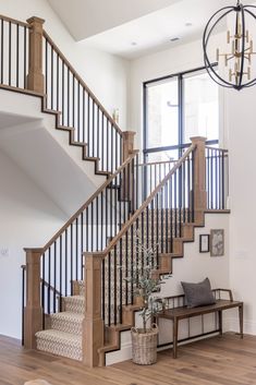 the stairs in this home are made of wood and wrought iron railings, along with a bench