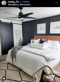 a bedroom with black walls and white bedding