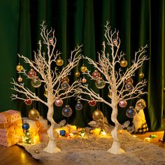 two white trees decorated with ornaments and lights