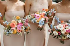 the bridesmaids are holding their bouquets together