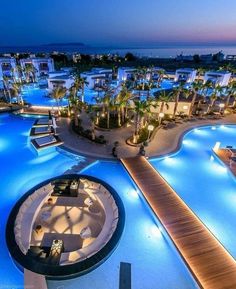 an aerial view of a resort at night with lights on the pools and palm trees