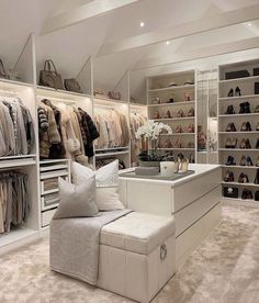 a large closet filled with lots of shoes and handbags on top of white shelves