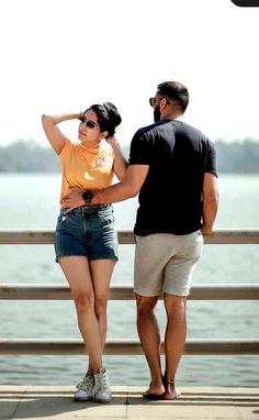 a man standing next to a woman on top of a pier