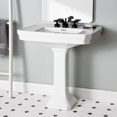 a white pedestal sink sitting next to a mirror