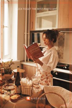 a woman standing in a kitchen reading a book