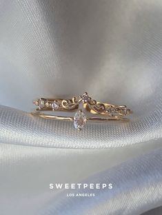 two gold wedding bands with diamonds on top and the words sweet pees written in white lettering