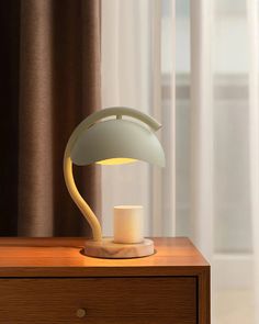 a table lamp sitting on top of a wooden dresser