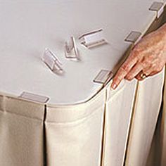 a person's hand on the top of a bed with several pins stuck to it