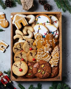 a wooden box filled with lots of different types of cookies and other holiday treats on top of a table