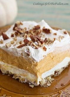 a piece of cake with frosting and pecans on top